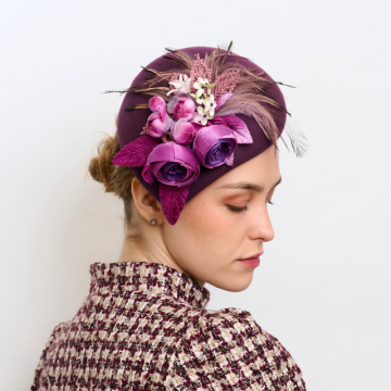 A V V Chapeaux Plum percher hat decorated with fabric  flowers and soft matching feather wisps.