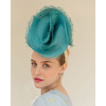 A V V Chapeaux headpiece featuring a Teal sinamay disk with raw edges folded into a swirling twist at the front, finished at the back with a trio of Viola Azura dahlias as a surprise.
