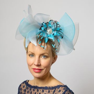 A V V Chapeaux headpiece of swirling Kingfisher, Pale Lobelia and Viola Azura blue crinoline on a cream sinamay halo headband with a handmade Blue and Black crinoline waterlily with a Clotted Cream pearl in the centre. 
