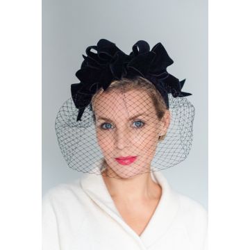 A V V Chapeaux headdress featuring a row of Black Double Sided Velvet bows upon bows and finished with an elegant layer of black merry widow veiling covering the whole face. 
